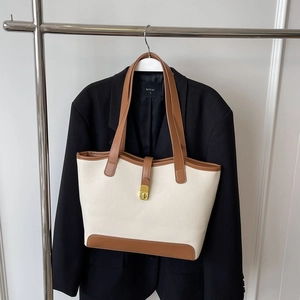 Large cream canvas tote bag with brown leather trim and gold buckle for daily commuting