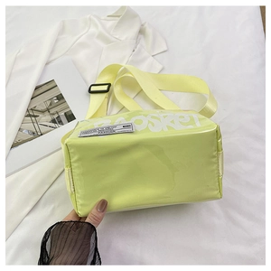 Detail of neon green crossbody bag with wide shoulder strap and black FASHION 1970 label