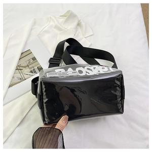 Close-up of black glossy jelly bag with graffiti print and wide nylon shoulder strap