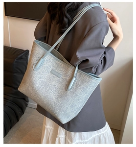 Detail of light blue tote bag featuring artistic ice-crack texture and leather logo patch