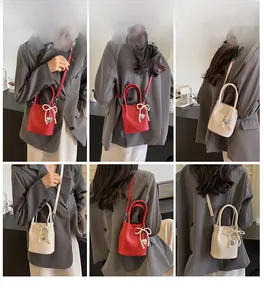 Vues détaillées du mini sac seau en cuir avec nœud perlé et pendentif cœur en deux couleurs