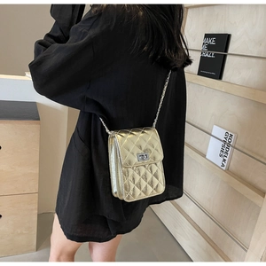 Macro view of gold quilted crossbody mini bag with metallic finish and chain strap
