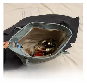 Spacious interior of blue-grey tote bag showing cosmetics and cream stored inside