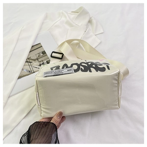 Detail of creamy white jelly bag featuring street style graffiti and wide nylon strap