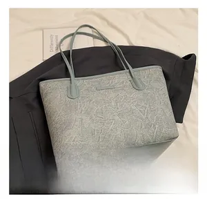 Detailed view of large tote bag featuring unique rock texture and slim shoulder straps