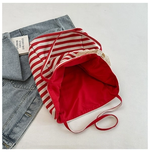Detail of red and white striped canvas tote bag with lace bow and large opening
