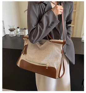 Detail of canvas tote bag with brown leather trim and tassel on a female model