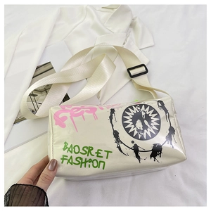 Detail of trendy graffiti cream crossbody bag featuring a wide adjustable strap