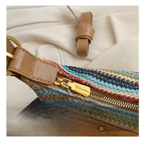 Détail de la texture tissée colorée et de la fermeture éclair dorée sur le sac bandoulière
