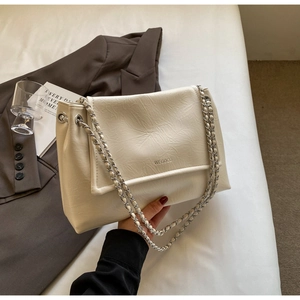 Detail of off-white shoulder bag with natural wrinkled texture and silver chain strap