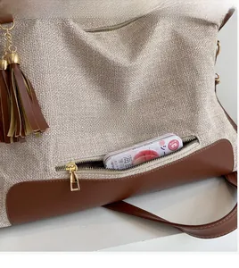 Detail of canvas bag with color-block stitching, zipper pocket, and leather tassel decor
