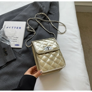 Detailed close-up of champagne gold quilted crossbody bag with metal chain and turn-lock