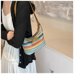 Gros plan du sac bandoulière en maille arc-en-ciel avec une sangle en cuir marron