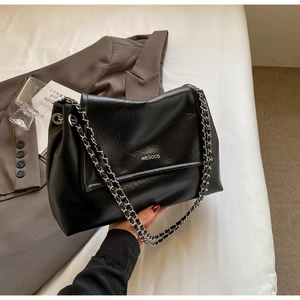 Detail of black wax leather shoulder bag featuring silver chain and brand logo