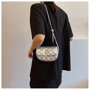 Close-up of a silver quilted leather shoulder bag with metallic chain and twist lock