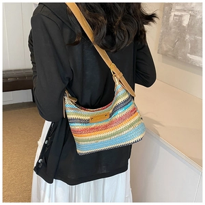 Détail du sac à bandoulière en raphia tissé coloré avec sangle en cuir sur modèle