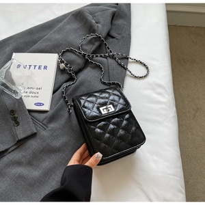 Detailed close-up of the black quilted leather mini bag featuring a silver metal turn-lock