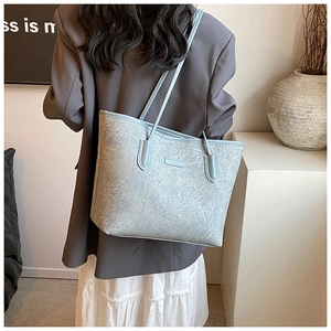 Detail of light blue marble textured tote bag showing stitching and shoulder strap quality