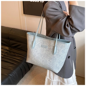 Detail of light blue tote bag with unique marble texture and rectangular leather patch