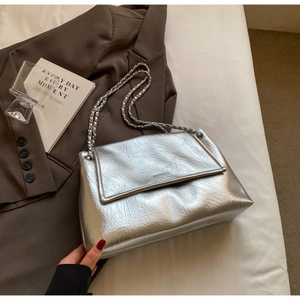 Detailed view of silver metallic bag with pleated texture and silver chain strap