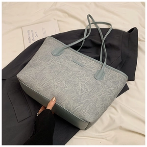 Detailed view of light blue tote bag with marble textured material and slim handles