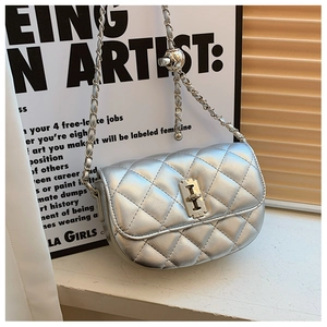 Detail of silver quilted saddle bag with metal turn-lock and adjustable chain strap
