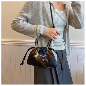 Detail of artistic oil painting bucket bag featuring textured fabric and drawstring closure