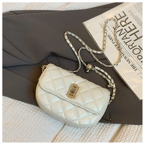 Detail shot of ivory quilted saddle bag with golden chain strap and twist lock