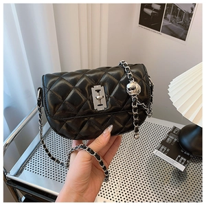 Close-up of black quilted saddle bag featuring silver hardware and glossy PU leather finish