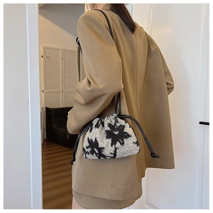 Detail of drawstring bucket bag with black floral print and white textured fabric