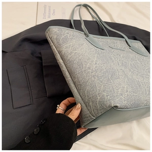 Detail view of light blue tote bag showing unique marble texture and slim straps