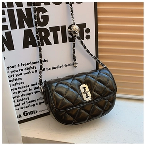 Detail of black quilted leather crossbody bag with silver chain and adjustable metal ball
