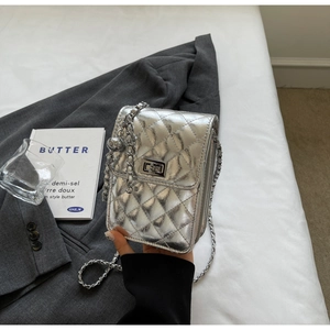 Close-up of a silver quilted crossbody bag with metal chain strap and twist-lock closure