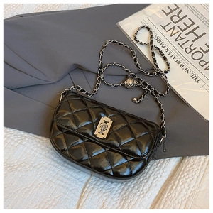 Detail of black quilted leather bag with silver chain strap and adjustable metal ball buckle