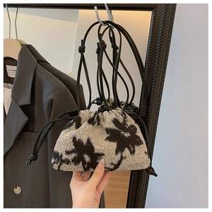Detail of vintage oil painting style bucket bag featuring black star patterns and drawstring