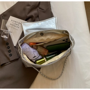 Interior view of large silver tote bag showing capacity for phone and perfume