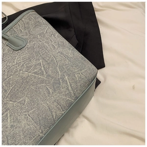 Detail shot of the reinforced leather corner stitching on the blue stone texture tote bag