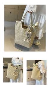 Close-up of woven straw tote bag featuring decorative tassel with blue and white beads