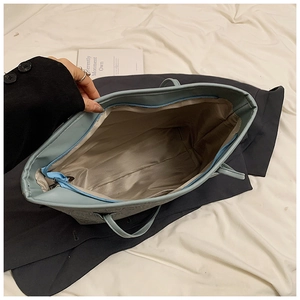 Interior view of the spacious light blue tote bag showing zipper closure and lining
