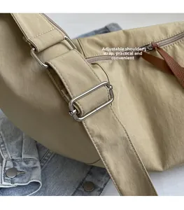 Detail of adjustable nylon shoulder strap with metal buckle and brown leather puller