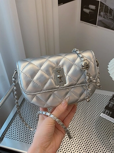 Silver quilted saddle crossbody bag with chain strap and metallic industrial buckle