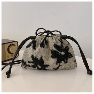 Detail of vintage oil painting bucket bag with floral drawstring and retro radio decor