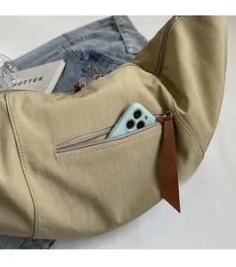 Detail showing back zipper pocket on khaki nylon half-moon crossbody bag for daily storage