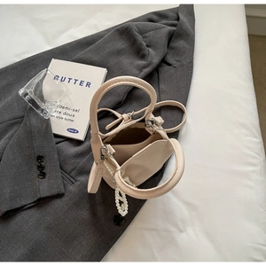 Vue détaillée d'un mini sac cabas beige en cuir grainé avec une chaîne décorative en perles