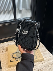 Quilted black leather mini crossbody bag with silver chain strap and metal turn-lock