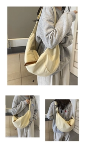 Close-up of a large beige canvas dumpling bag with adjustable wide shoulder straps