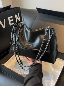 Large black pleated leather shoulder bag with silver chain strap and logo detail
