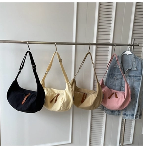 Detail view of four colorful crescent canvas crossbody bags with adjustable straps