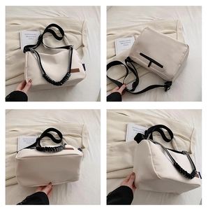 Détail du sac bandoulière en toile blanc cassé avec poignée en corde tressée et poche zippée noire