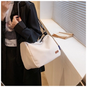 Détail du sac cabas blanc cassé avec une bandoulière en corde tressée noire et blanche
